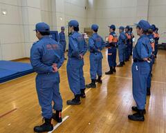 訓練礼式にて整列休めの姿勢の研修を受ける団員の写真