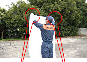 濡らしたシーツを両手で持ち、体の前面で広げます。の画像