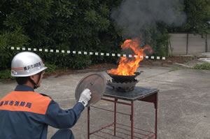 やけどをしないように注意し、天ぷらナベに対してできるだけ低い姿勢を取り炎と熱気から身を守ります