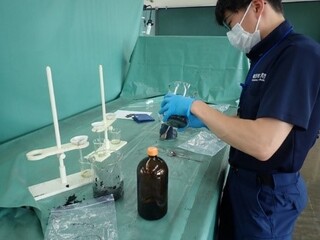 <分析試料の前処理を行う鑑識員>