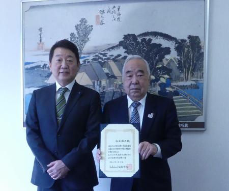Mr. Shiraishi holding a certificate of commendation