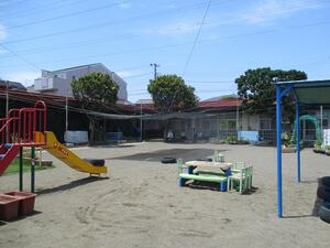 The Yokodai-Daini Nursery School Garden is a one-story building with playground equipment.