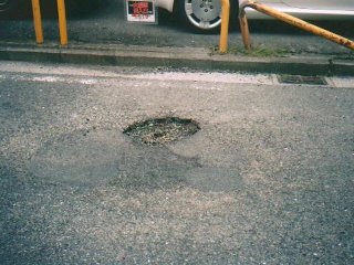 道路にあいた穴の写真