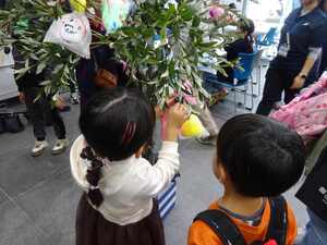 会場内の木に取り付けるこどもたち