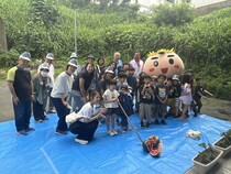割ったスイカを前にみんなで記念写真