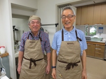 団体のメンバーでおそろいのエプロンを着ている様子