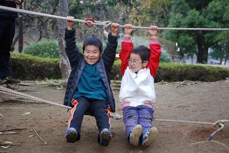 子どもがロープのブランコで楽しそうに遊ぶ様子