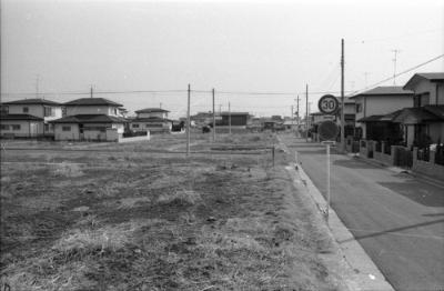 Quang cảnh đường phố gồm những ngôi nhà biệt lập ở Shiranedai, nhìn về hướng Kamishirane 3-chome 16 từ khu đất trống ở phía trước. Một con đường trải dài từ trước ra sau bên phải.