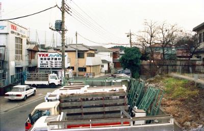 志田硝子建材の看板がある社屋が左。同社前の道は奥から手前にバス停「立丁場」方面へ抜ける。