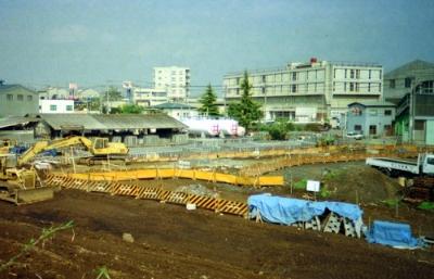 右に矢崎総業の大きな建物。横浜四季の森フォレオが社屋跡地に現在建っている。社屋手前には仮囲いがある。