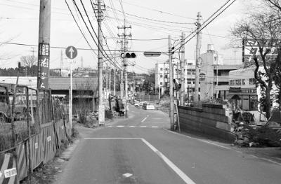 中原街道から見た都岡小学校。中央が都岡小学校。右端に横浜日産営業所の看板がある。