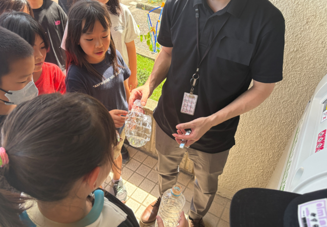 投入後のペットボトルを児童が観察している写真
