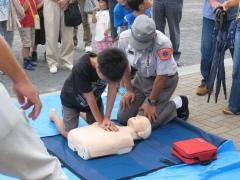 防災訓練で人工呼吸を学ぶ少年