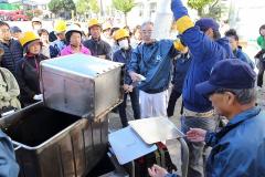 방재 훈련에서 비축품의 사용법을 배우는 사람들