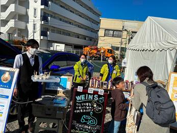 Tasting booth of new rice cooked with electric power from electric vehicle