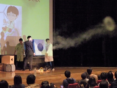 A picture of Dr. Ranma fired an air cannon from the stage