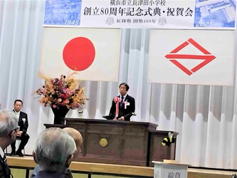 横浜市緑区長が長津田小学校80周年記念式典で祝辞を述べる場面
