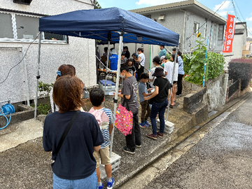 自治会館前の道路まで行列が伸びています 