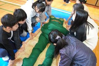 毛布で応急担架をつくる子どもたち 