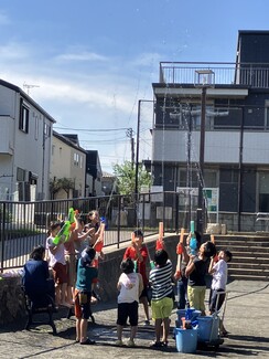 水鉄砲で遊んでいるこどもの写真